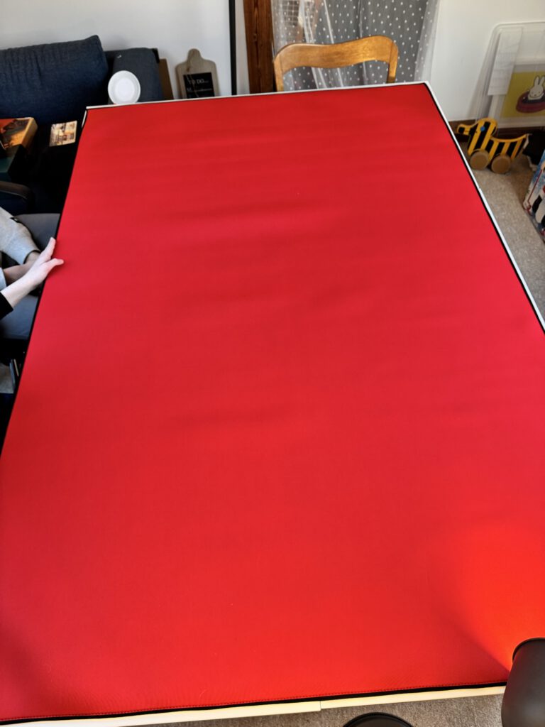 [Bild 3: Ausgerollte Neoprenfläche in Rot]